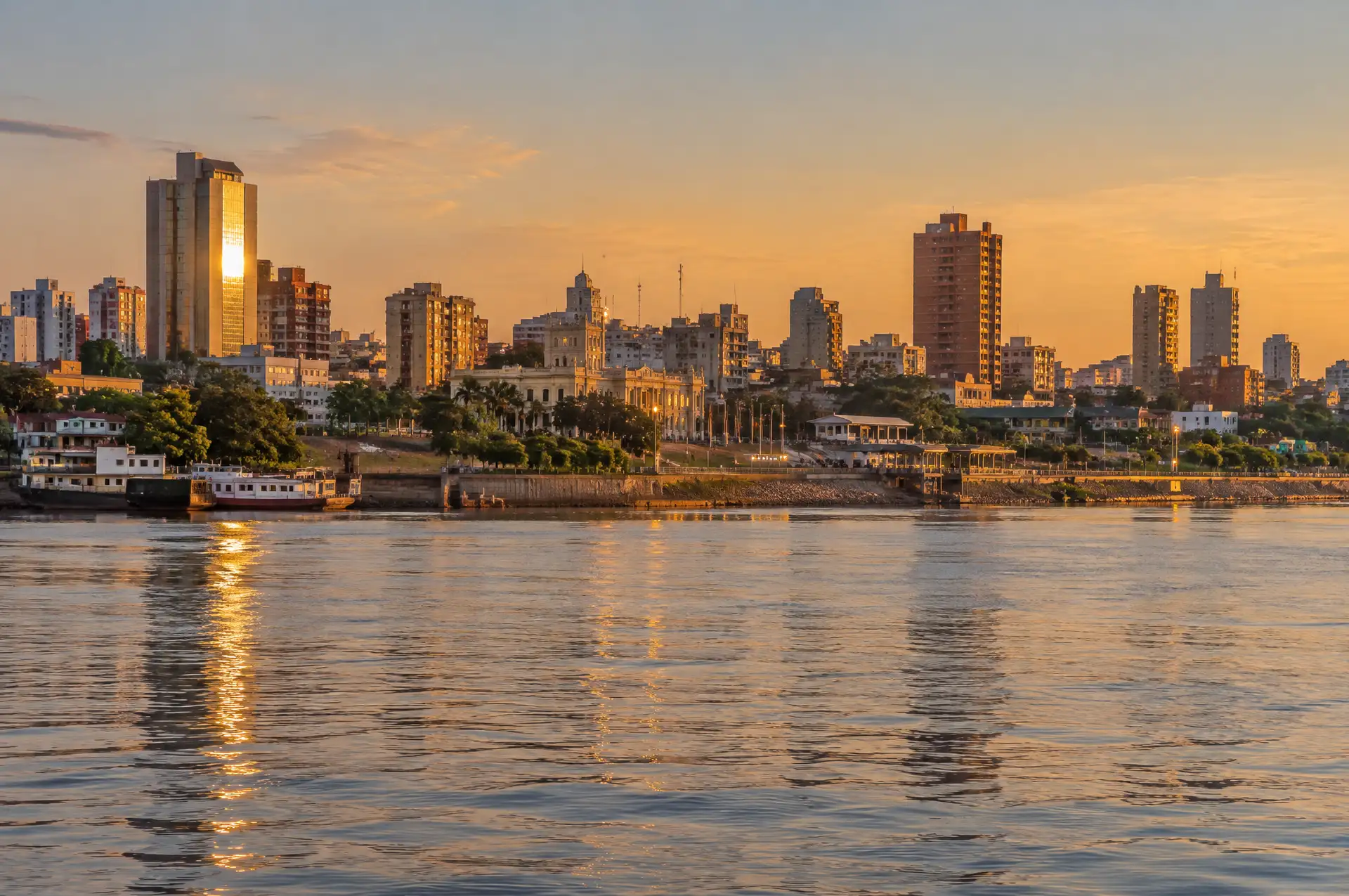 Illustration of the Asunción skyline seen across the Paraguay River at golden hour