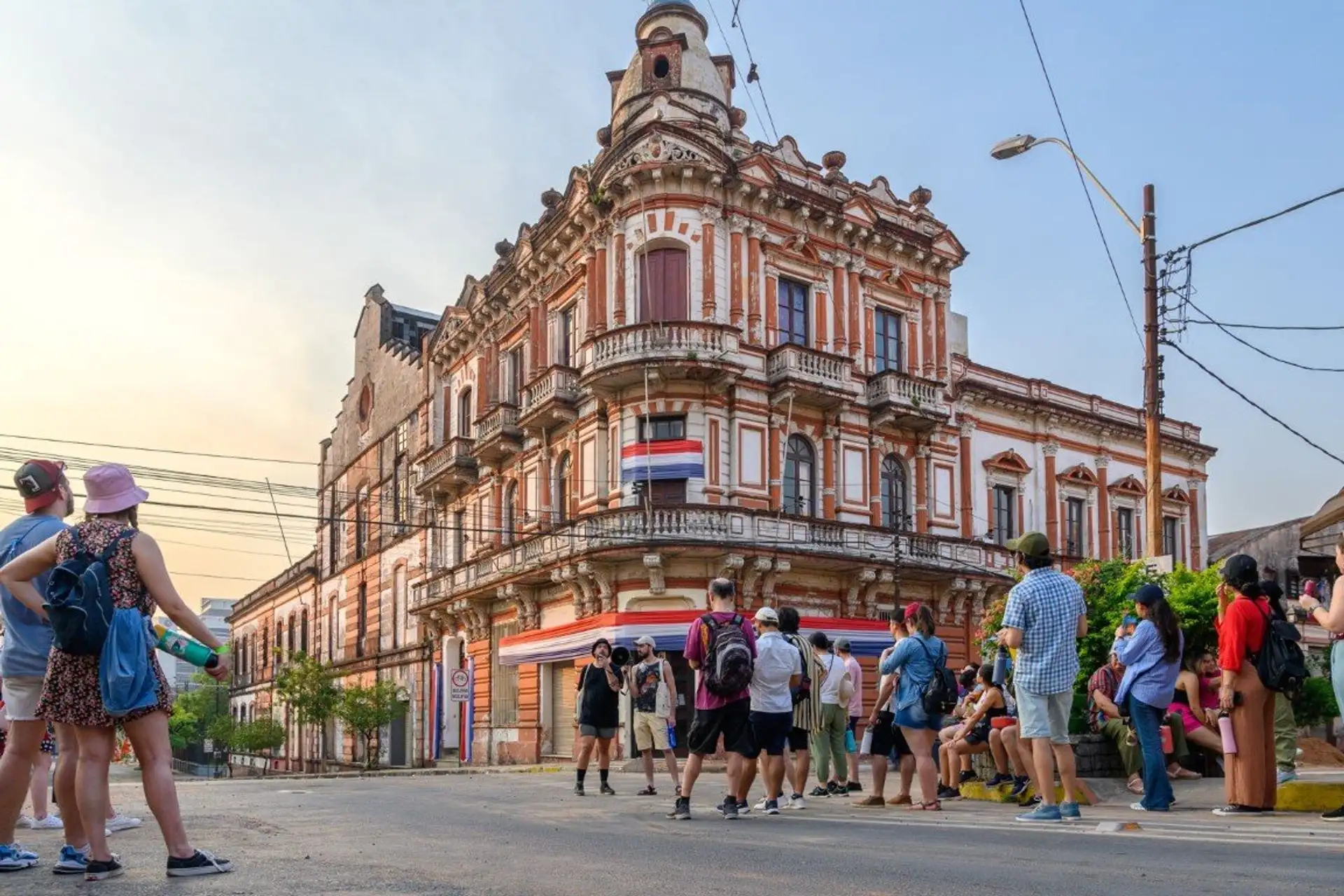 Tourists gather in front of a restored historic building on a downtown Asuncion street