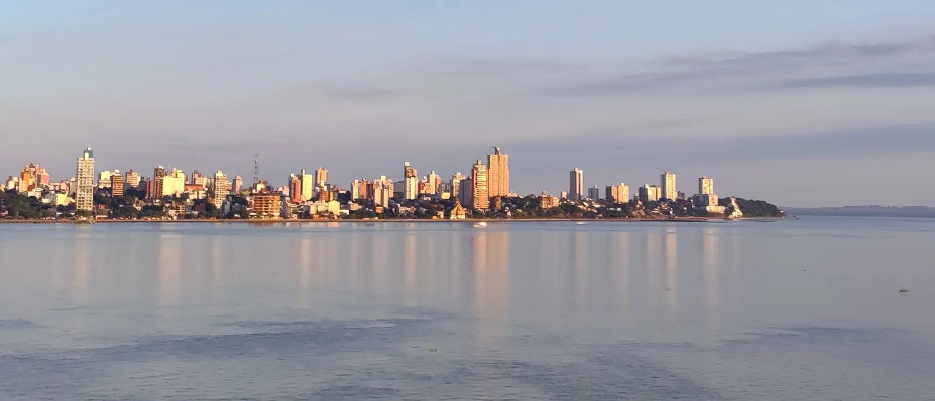 Skyline of Encarnacion city seen across the water at golden hour
