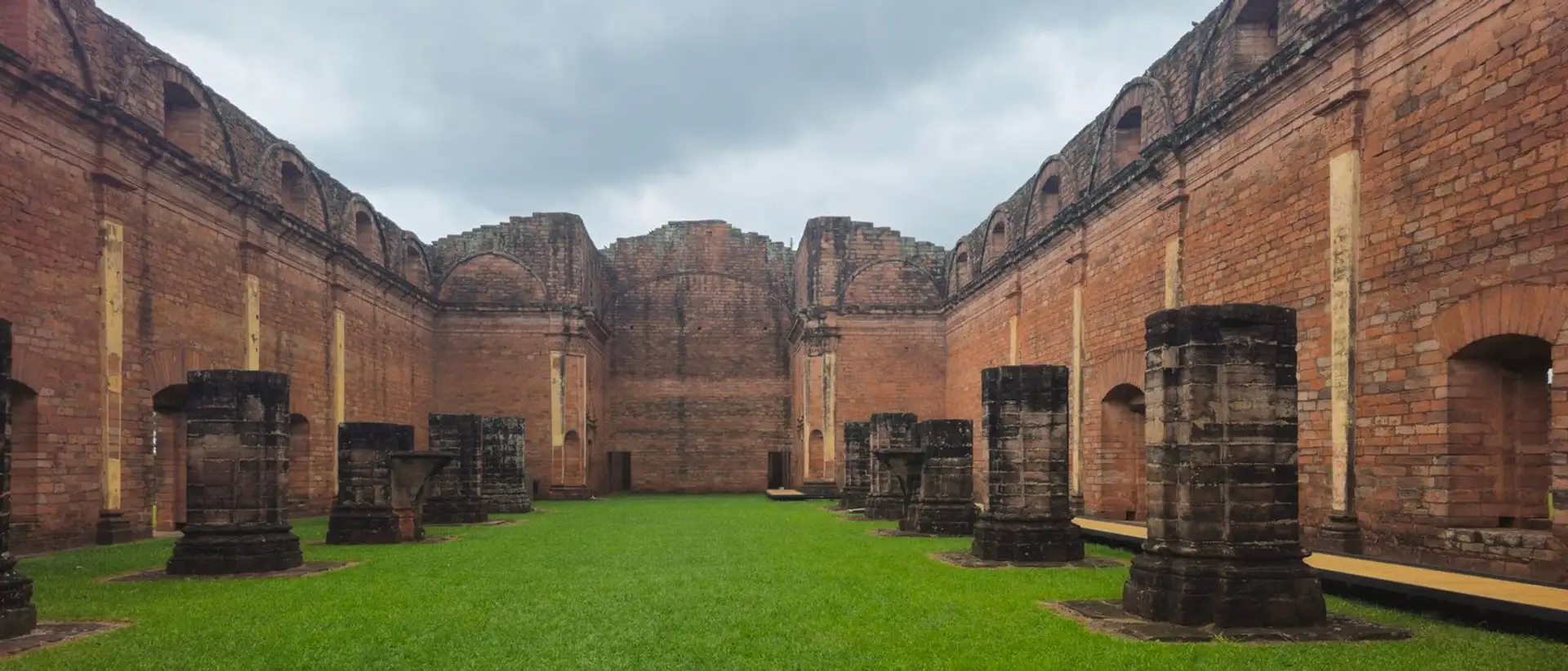 Brick columns and grass courtyard of the Jesuit ruins of Trinidad in Paraguay